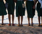 Group of girls standing in font of the waterline of the  ocean at Cochin Beach, India