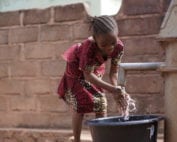 Small African Girl Washing Her Hands At The Village Well